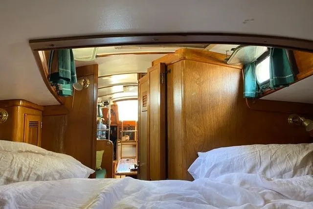 Slide: The Image of Interior of 1987 Cape Dory 36 sailboat with cozy wooden cabin and white bedding. - 25