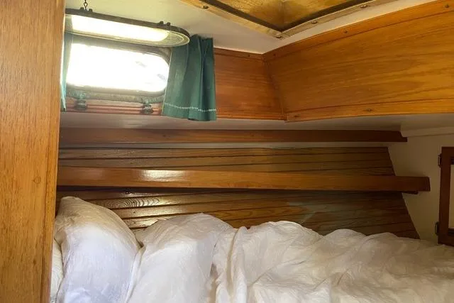 Slide: The Image of Cozy cabin interior of 1987 Cape Dory 36 sailboat with wooden paneling and bedding. - 26