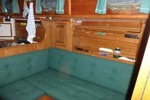Slide: The Image of Interior of 1987 Cape Dory 36 sailboat with green cushioned seating and wooden cabinetry. - 29