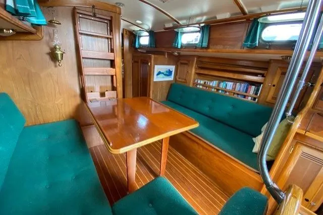 Slide: The Image of Interior of 1987 Cape Dory 36 sailboat with wooden furnishings and green upholstery. - 32