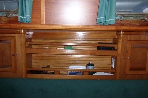 Slide: The Image of 1987 Cape Dory 36 interior with wooden cabinetry and green curtains. - 35