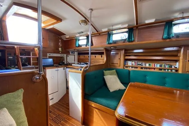 Slide: The Image of Interior of 1987 Cape Dory 36 sailboat with wooden furnishings and green upholstery. - 36
