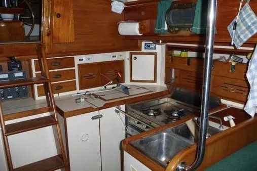 Slide: The Image of 1987 Cape Dory 36 yacht interior with wooden cabinetry, compact kitchen, and nautical equipment. - 37