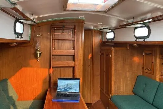 Slide: The Image of Interior of 1987 Cape Dory 36 sailboat with wooden furnishings and laptop on table. - 38