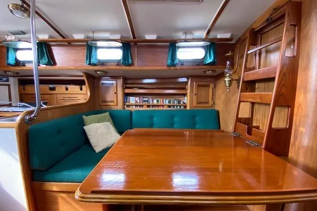 Slide: The Image of Interior of 1987 Cape Dory 36 sailboat with wooden table and teal seating. - 39
