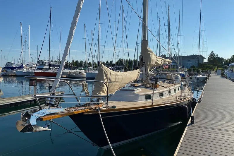 Slide: The Image of 1987 Cape Dory 36 sailboat docked at a marina with clear skies. - 4