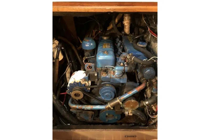 Slide: The Image of 1987 Cape Dory 36 engine compartment with blue marine engine and hoses. - 45