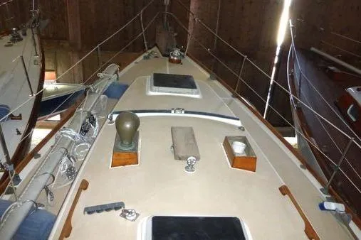Slide: The Image of 1987 Cape Dory 36 sailboat deck view, showcasing rigging and deck fittings in storage. - 46
