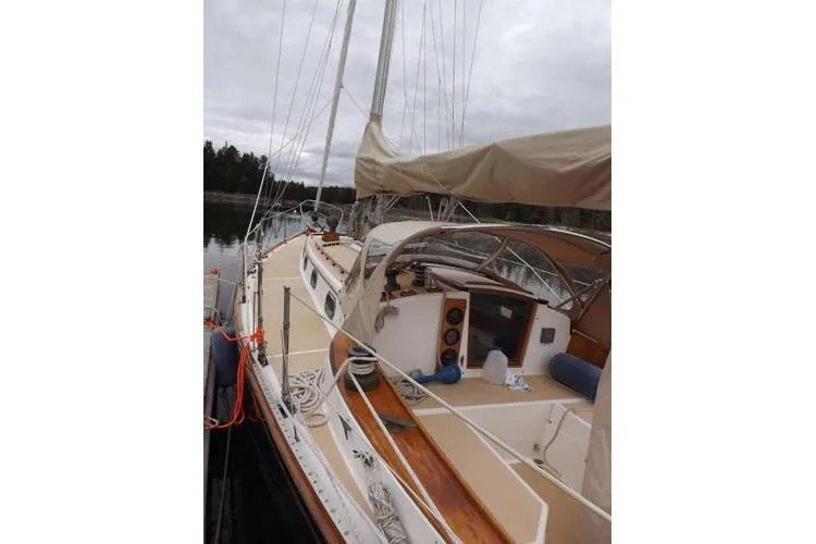 Slide: The Image of 1987 Cape Dory 36 sailboat docked, featuring beige deck and covered cockpit. - 5