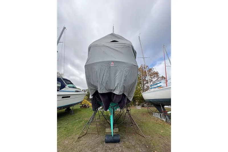 Slide: The Image of Covered 1987 Cape Dory 36 sailboat on land, surrounded by other boats, under cloudy sky. - 54