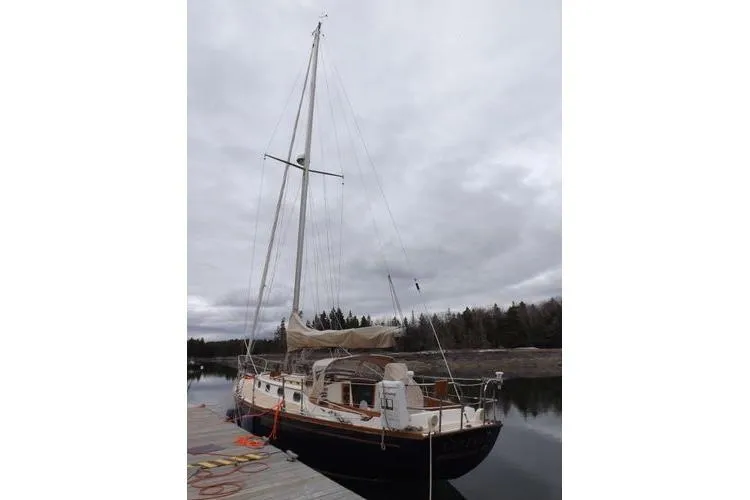 Slide: The Image of 1987 Cape Dory 36 sailboat docked on a cloudy day, showcasing its classic design. - 7