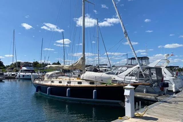 Slide: The Image of 1987 Cape Dory 36 sailboat docked at a marina under a clear blue sky. - 8