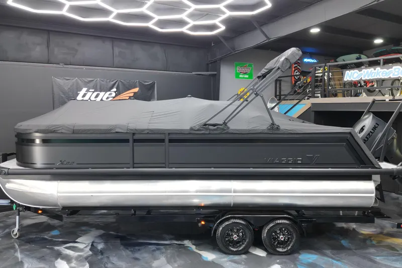 Slide: The Image of 2026 Viaggio Lago X-S 22 pontoon boat with cover in showroom setting. - 12