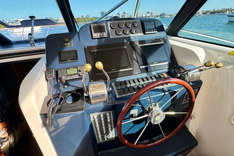 Slide: The Image of Helm of 2004 Tiara Yachts 3800 Open with navigation controls and steering wheel. - 7