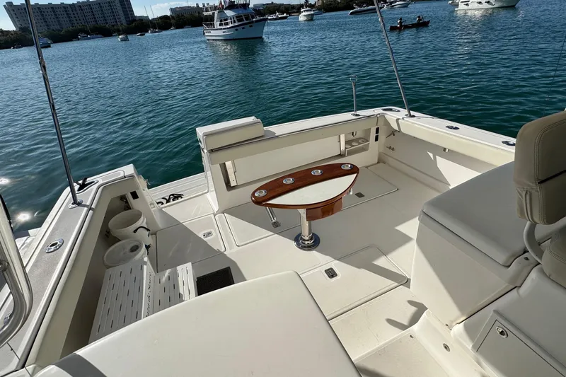 Slide: The Image of 2004 Tiara Yachts 3800 Open cockpit with seating and table, docked on calm water. - 8