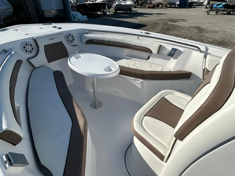 Slide: The Image of 2025 Tidewater 232 LXF boat interior with white and brown seating and round table. - 12