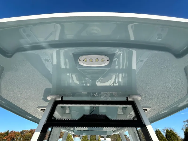 Slide: The Image of 2025 Tidewater 232 LXF boat T-top with LED lights under clear blue sky. - 15