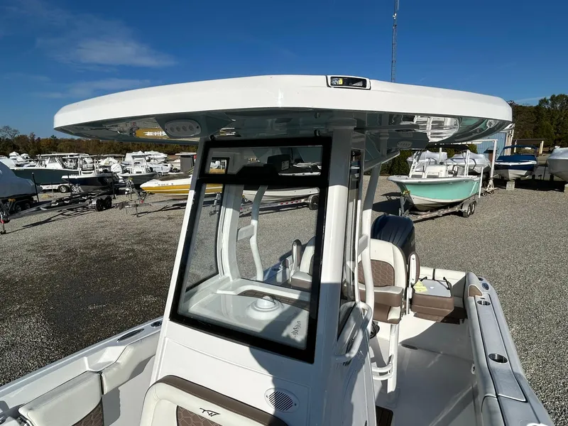 Slide: The Image of 2025 Tidewater 232 LXF boat with T-top, parked in a marina under clear blue skies. - 16