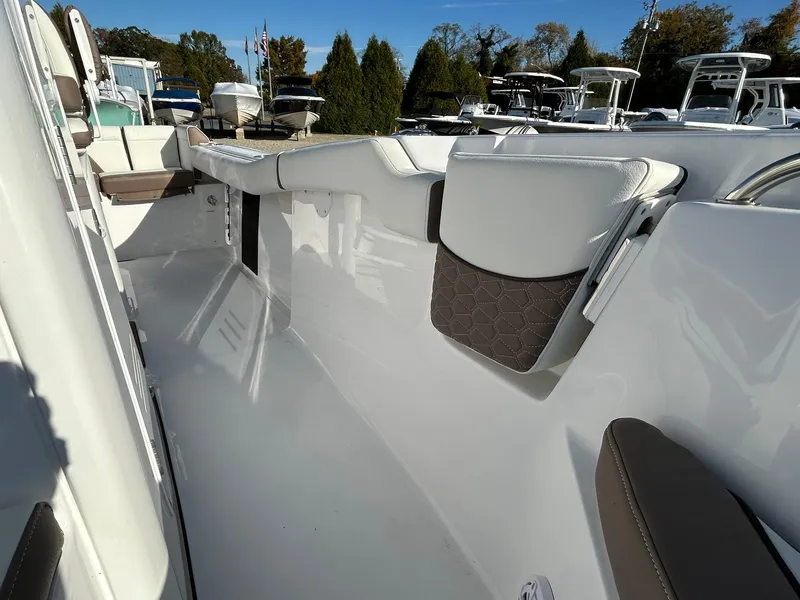 Slide: The Image of 2025 Tidewater 232 LXF boat interior, featuring sleek white and brown seating. - 18
