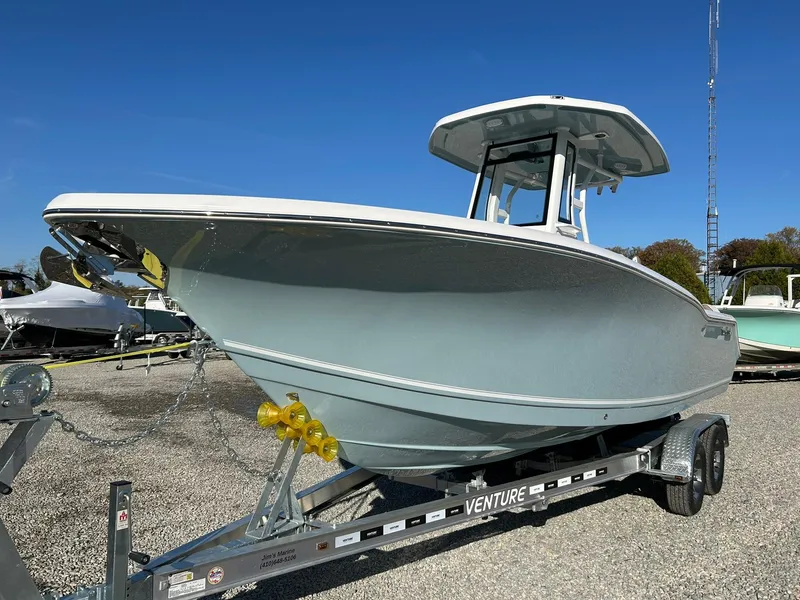 Slide: The Image of 2025 Tidewater 232 LXF boat on trailer, displayed outdoors under clear blue sky. - 2