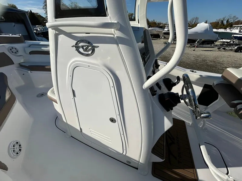 Slide: The Image of 2025 Tidewater 232 LXF boat interior with steering wheel and storage compartment. - 20