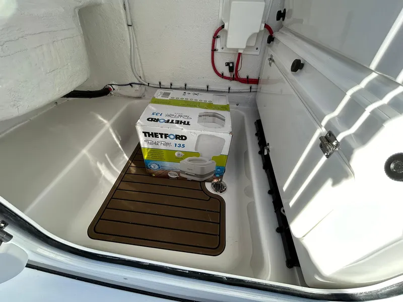 Slide: The Image of 2025 Tidewater 232 LXF boat storage compartment with Thetford Porta Potti 135. - 22