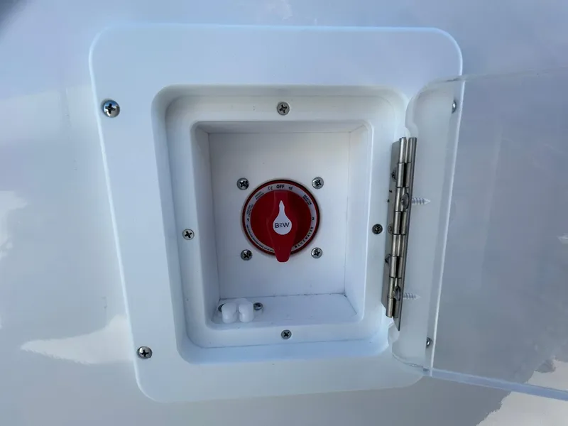 Slide: The Image of 2025 Tidewater 232 LXF boat battery switch compartment with red dial. - 26