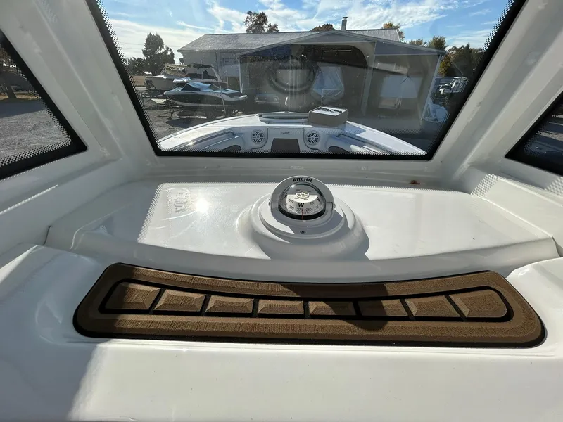 Slide: The Image of 2025 Tidewater 232 LXF boat dashboard with compass and windshield view. - 29