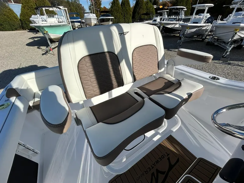 Slide: The Image of 2025 Tidewater 232 LXF boat seats, white and brown, in a marina setting. - 35