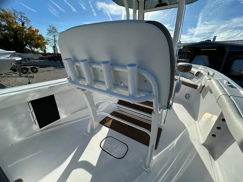 Slide: The Image of 2025 Tidewater 232 LXF boat interior with rod holders and seating under clear blue sky. - 44