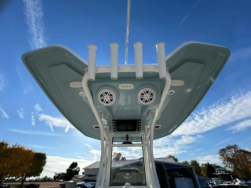 Slide: The Image of 2025 Tidewater 232 LXF boat with T-top and rod holders under clear blue sky. - 47