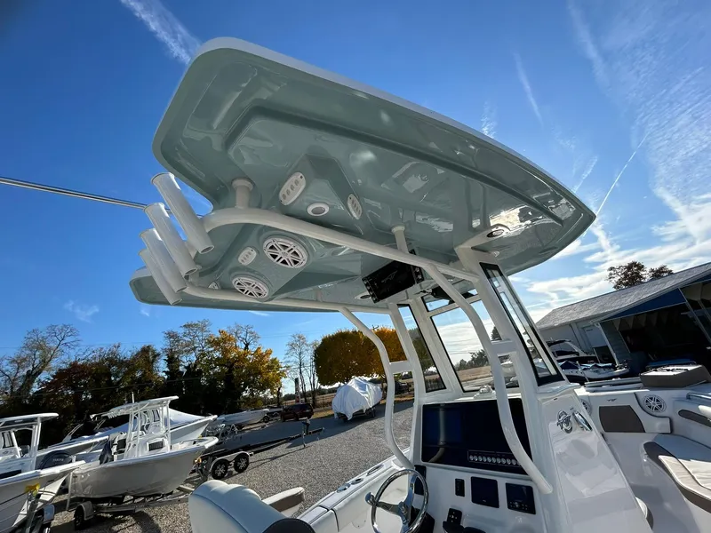 Slide: The Image of 2025 Tidewater 232 LXF boat with T-top and electronics, parked outdoors under clear sky. - 48