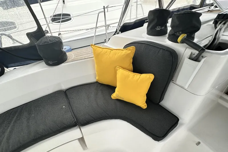 Slide: The Image of Cozy seating area on 2002 Hunter 466 sailboat with yellow cushions and black covers. - 11