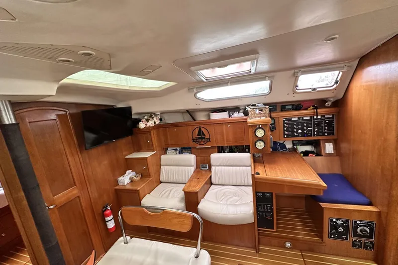 Slide: The Image of Interior of a 2002 Hunter 466 sailboat with wood paneling and seating area. - 25