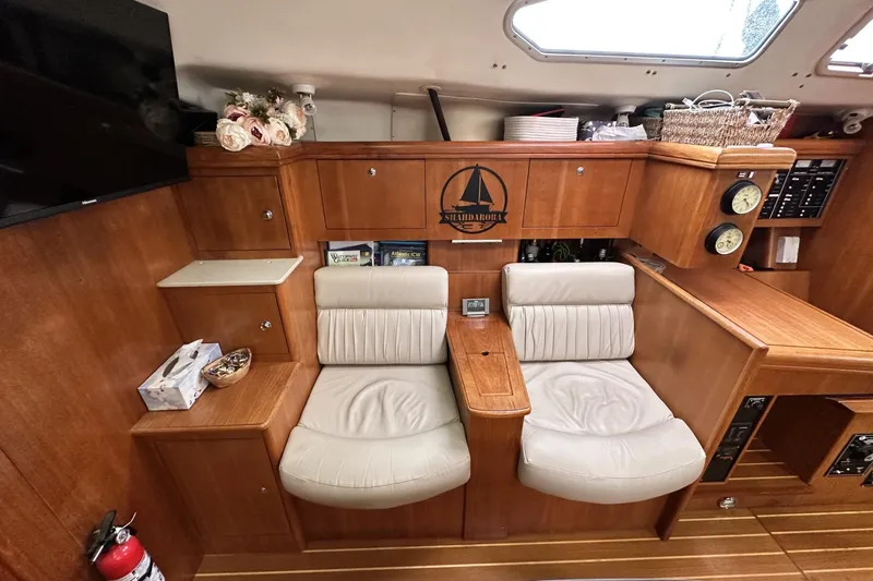 Slide: The Image of Interior of a 2002 Hunter 466 yacht with cozy seating and wooden cabinetry. - 26