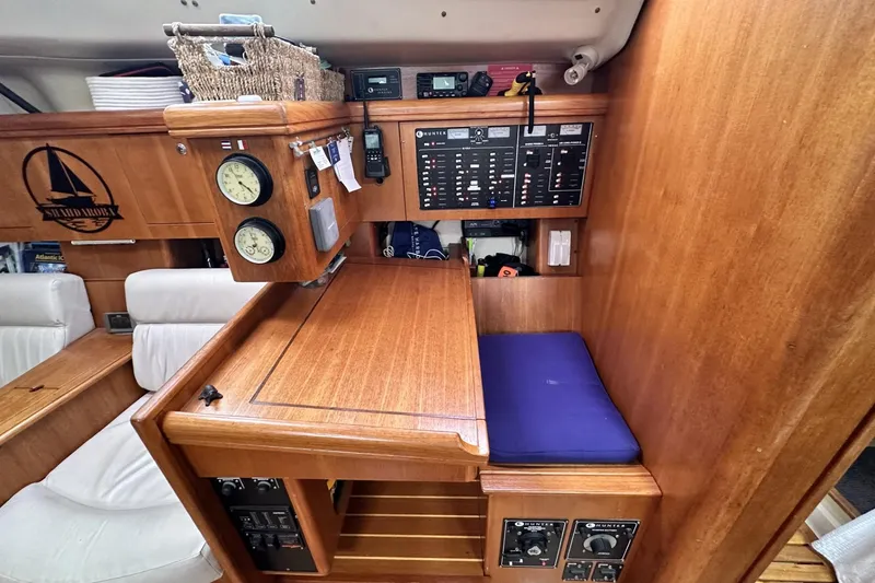 Slide: The Image of Navigation station in a 2002 Hunter 466 sailboat with control panels and seating. - 27