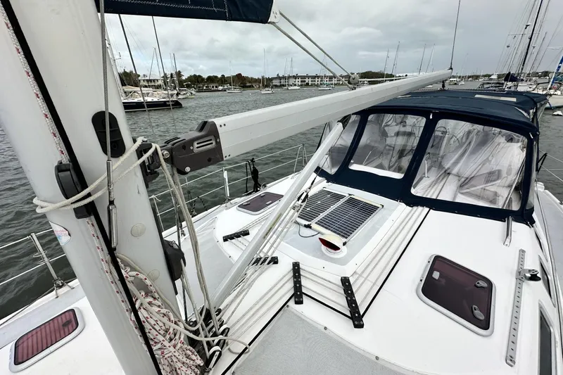 Slide: The Image of Sailboat deck view of 2002 Hunter 466, featuring rigging and marina background. - 3