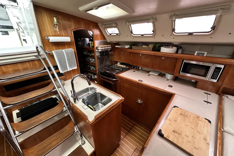 Slide: The Image of Luxurious 2002 Hunter 466 yacht kitchen with wood cabinetry, stainless steel sink, and modern appliances. - 32