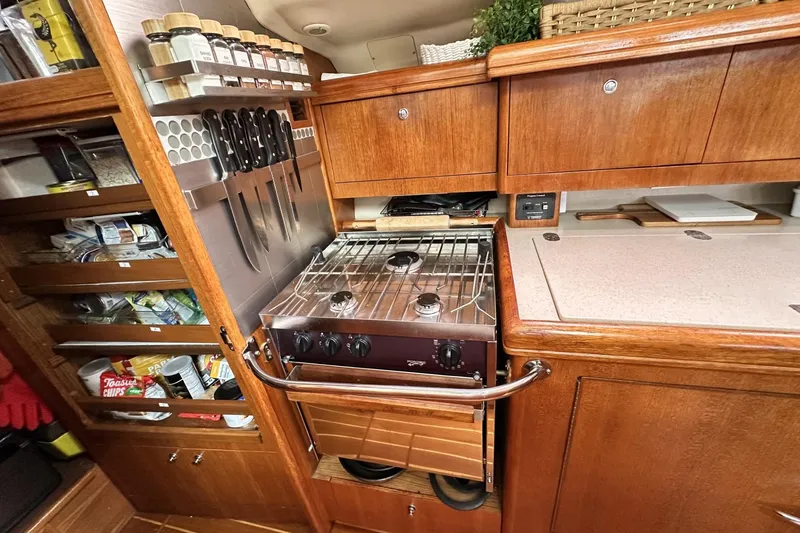 Slide: The Image of Compact kitchen in a 2002 Hunter 466 yacht with stove, spice rack, and storage. - 42