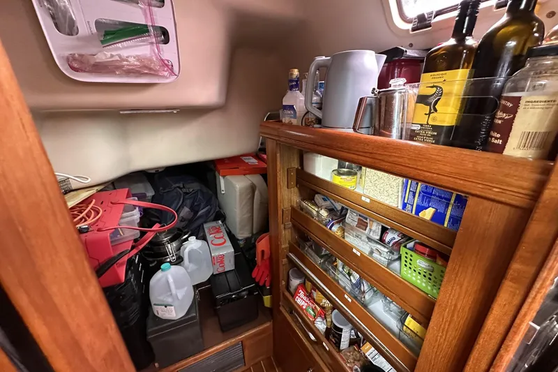 Slide: The Image of Storage area in a 2002 Hunter 466 yacht, filled with supplies and provisions. - 43