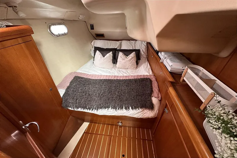 Slide: The Image of Interior of a 2002 Hunter 466 yacht, cozy bedroom with wooden furnishings. - 44