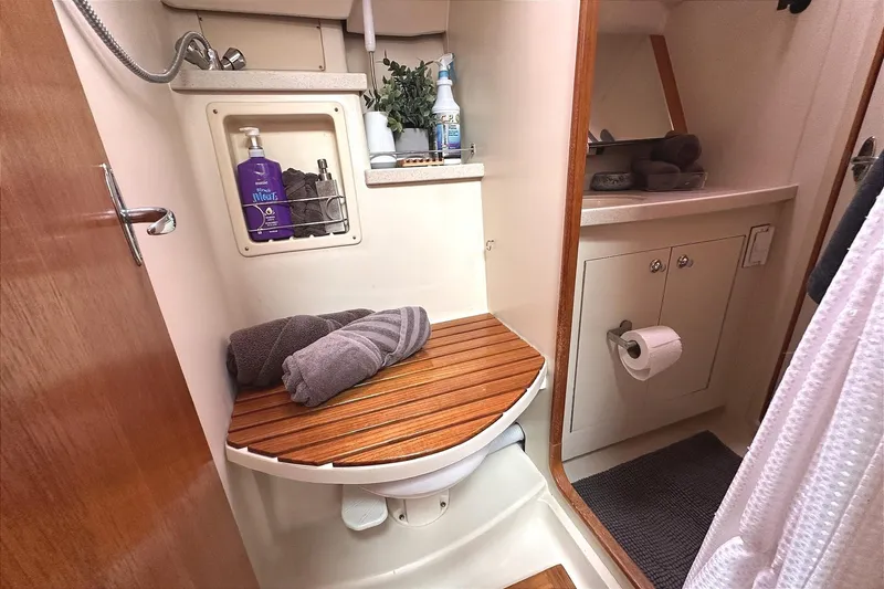 Slide: The Image of Bathroom in 2002 Hunter 466 boat with wooden accents and toiletries. - 46
