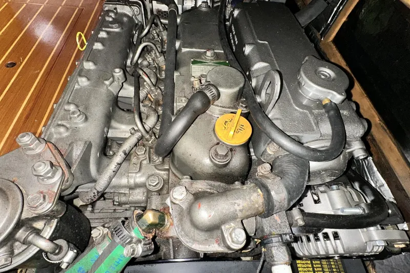 Slide: The Image of Engine of a 2002 Hunter 466 boat, showcasing mechanical components and hoses. - 47