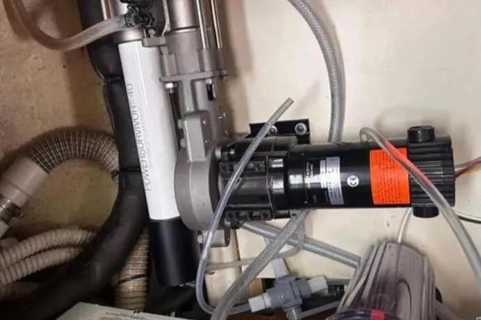 Slide: The Image of Engine compartment of a 2002 Hunter 466 sailboat, featuring mechanical components and hoses. - 49