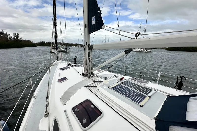 Slide: The Image of Sailboat Hunter 466 (2002) on water, featuring solar panel and rigging. - 5