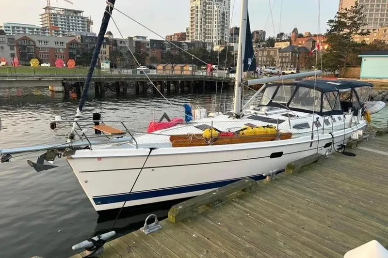 Slide: The Image of Sailboat docked at marina, Hunter 466 model, 2002, with cityscape background. - 53