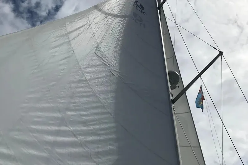 Slide: The Image of Sail of a 2002 Hunter 466 yacht against a cloudy sky. - 54