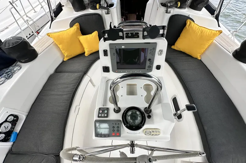 Slide: The Image of Cockpit of 2002 Hunter 466 sailboat with navigation equipment and yellow cushions. - 9