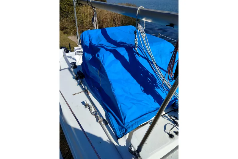 Slide: The Image of 1998 Hunter 240 sailboat deck with blue cover and rigging details. - 10