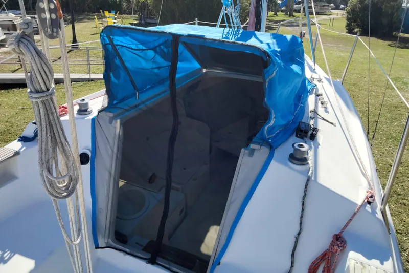 Slide: The Image of 1998 Hunter 240 sailboat with blue tarp-covered cabin entrance. - 11
